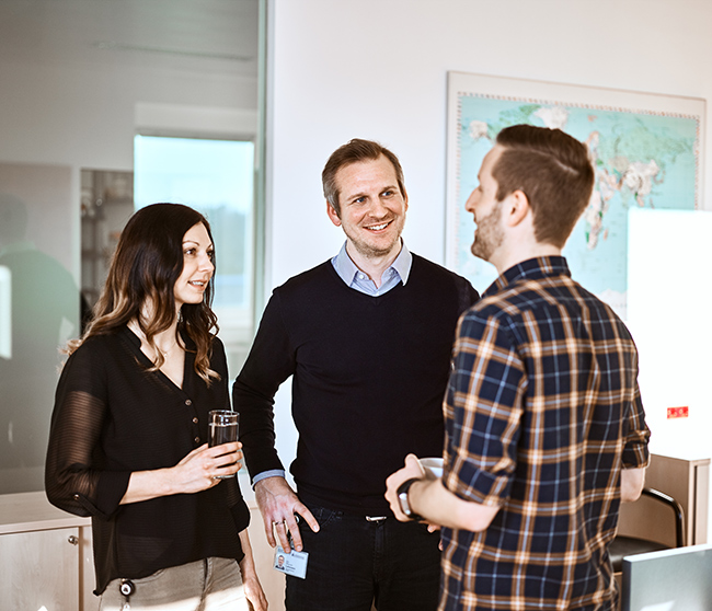 People standing in an office having a conversation