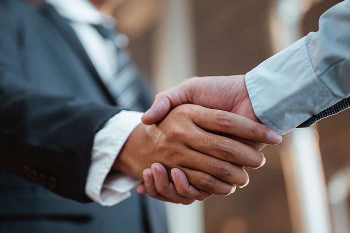 Close-up of a handshake between two people in formal attire