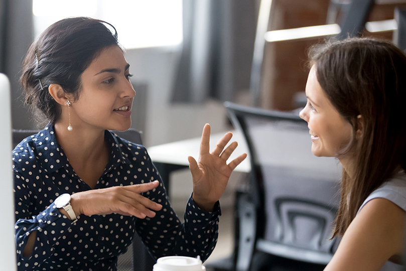 Two people sitting at a conference table in an office conducting an interview.