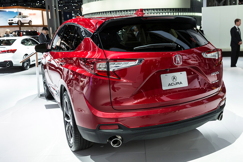 A red Acura RDX SUV displayed at an auto show