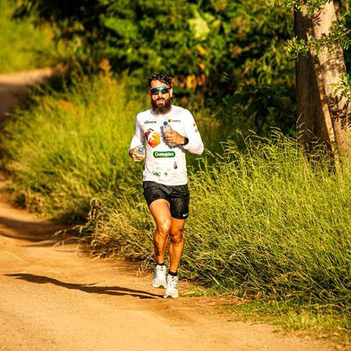 Tiarles Dos Santos running along a trail in the woods